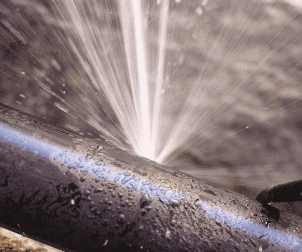 Water spraying from a leak in an exposed pipe
