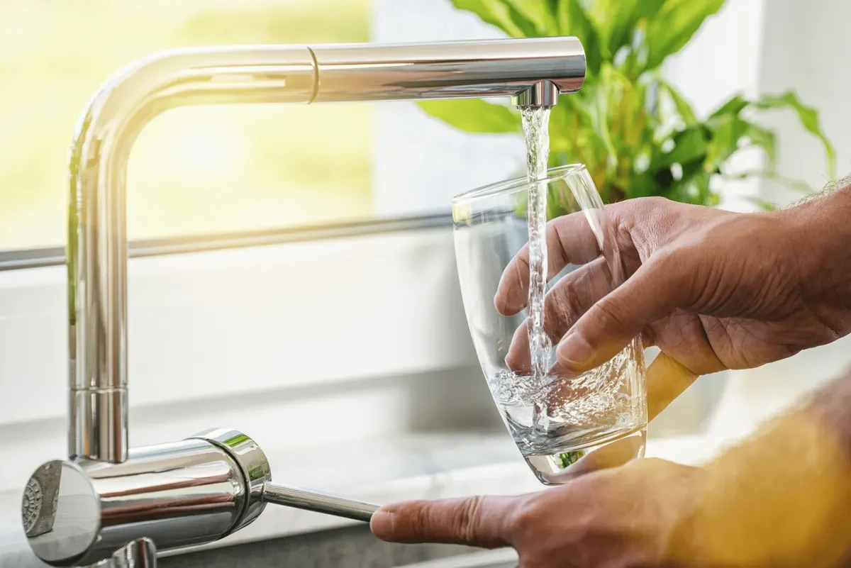 A glass being filled from a kitchen tap