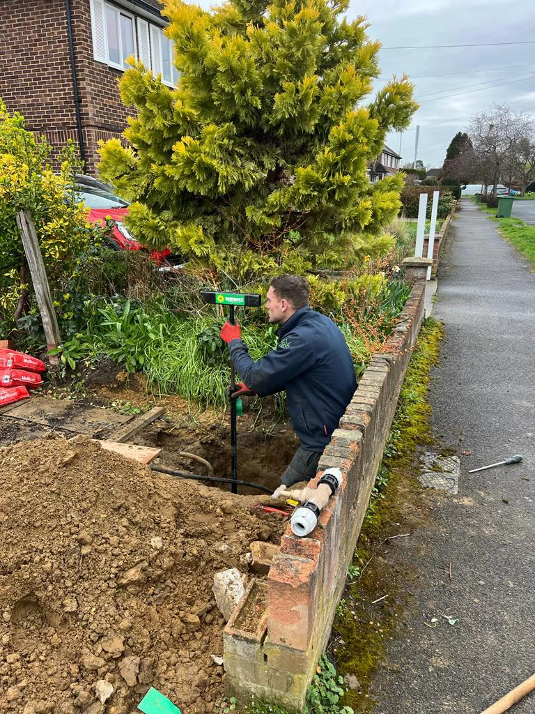 Engineer working in an excavation beside a garden wall