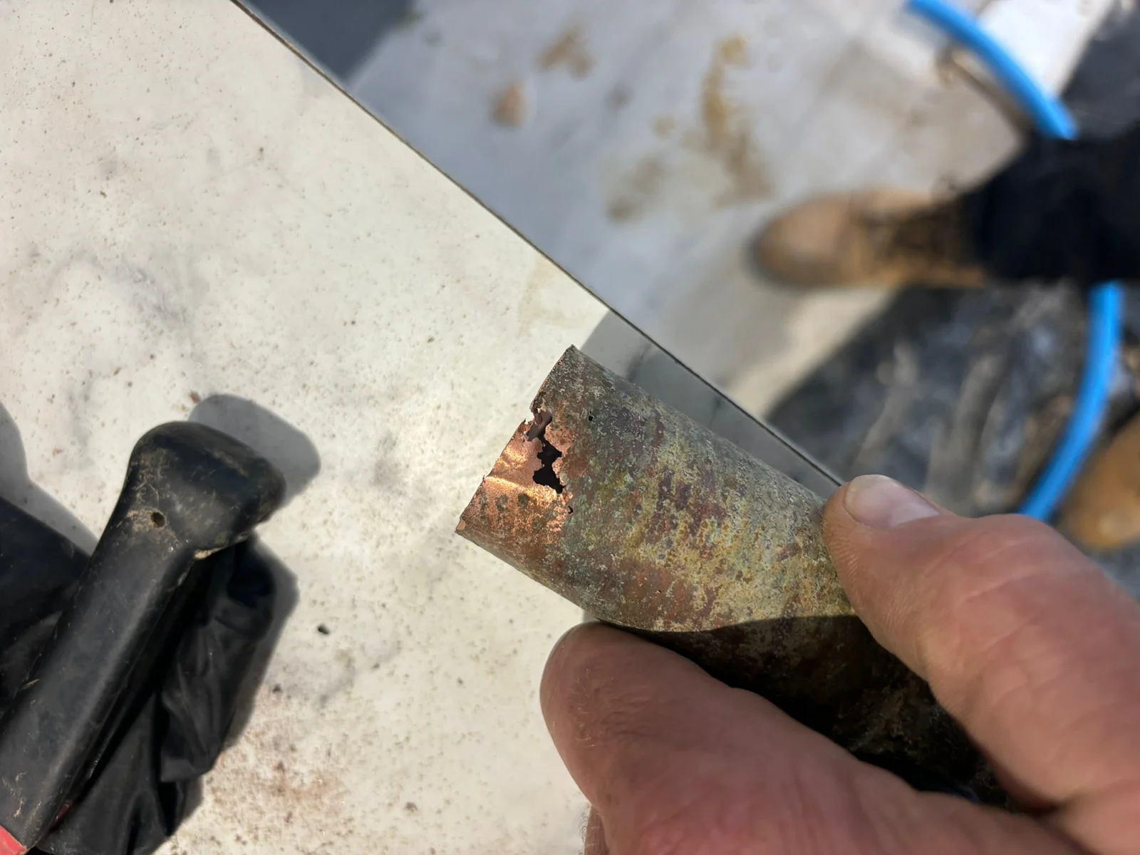Close-up of a removed pipe section showing corrosion