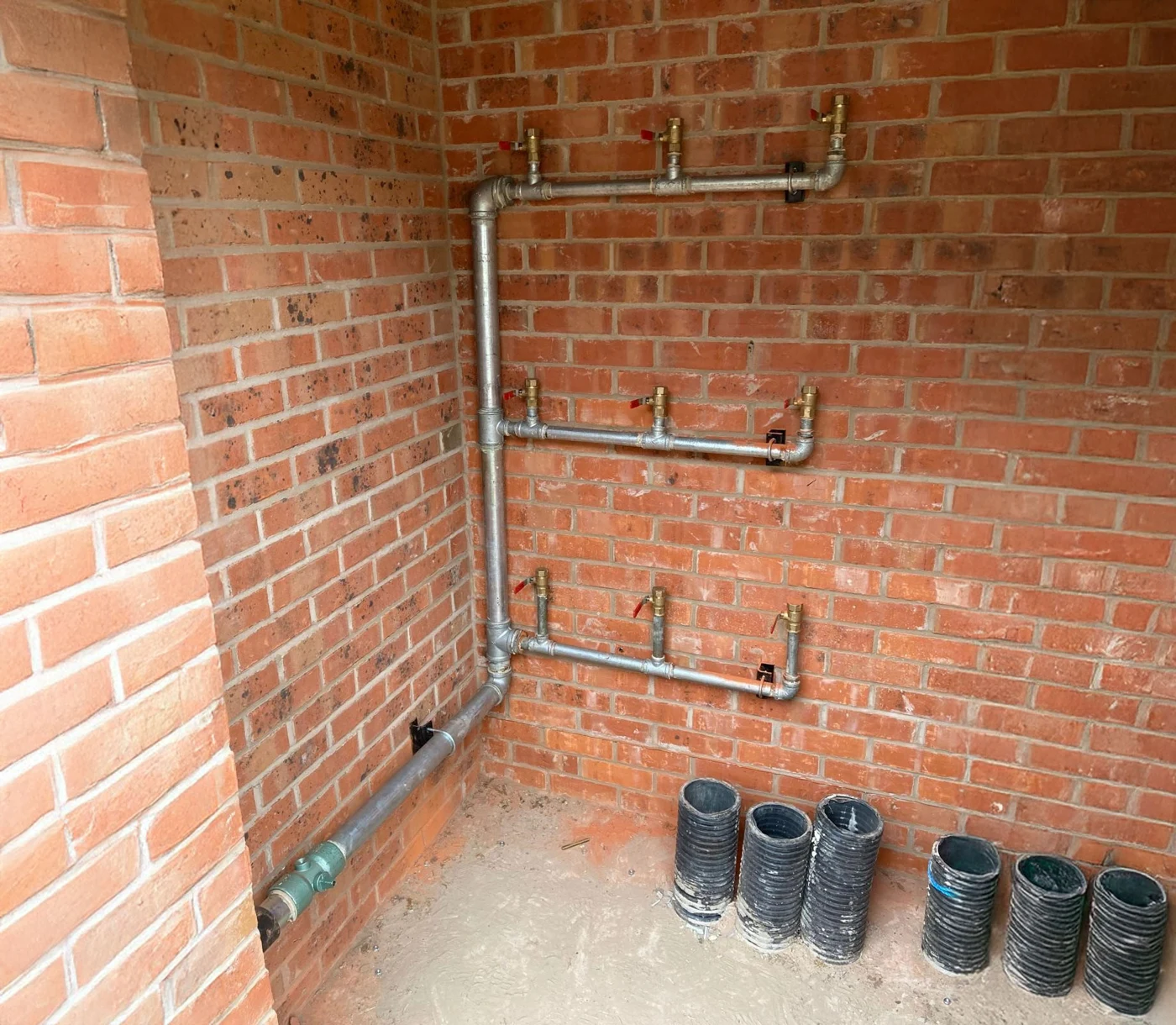 Metal pipework with multiple red-handled isolation valves