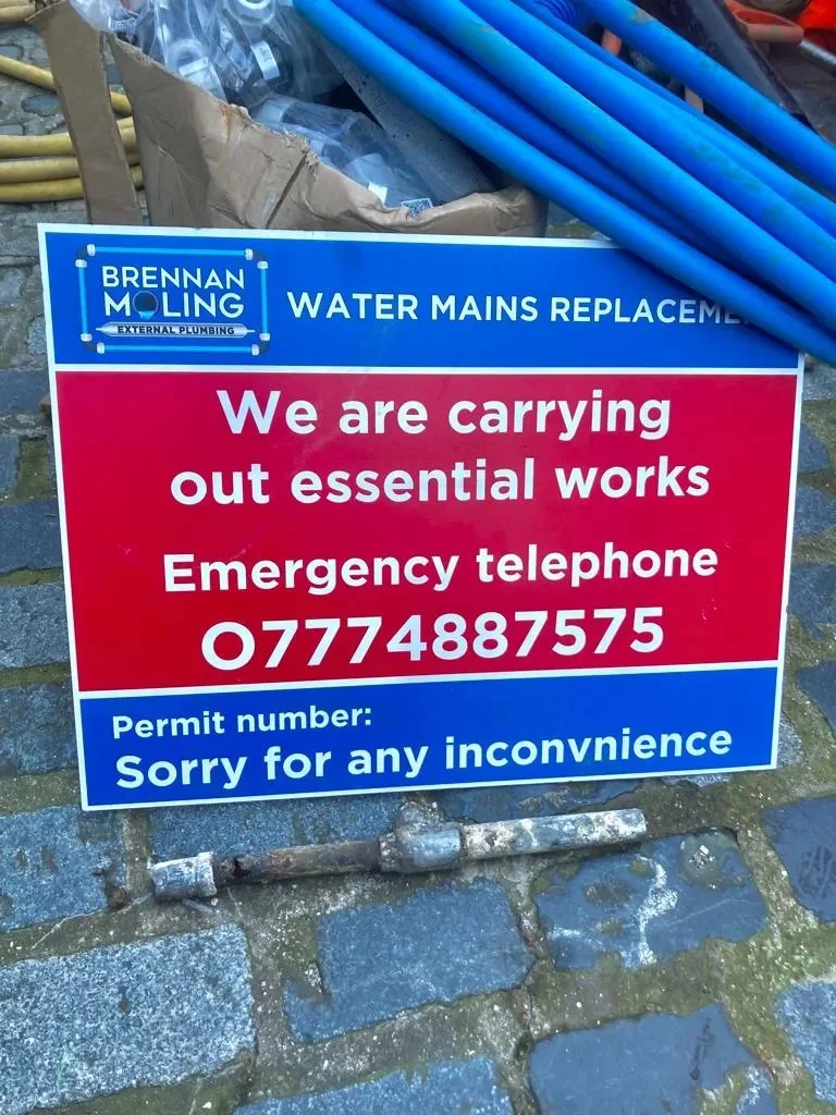 Brennan’s branded work notice beside blue pipework.