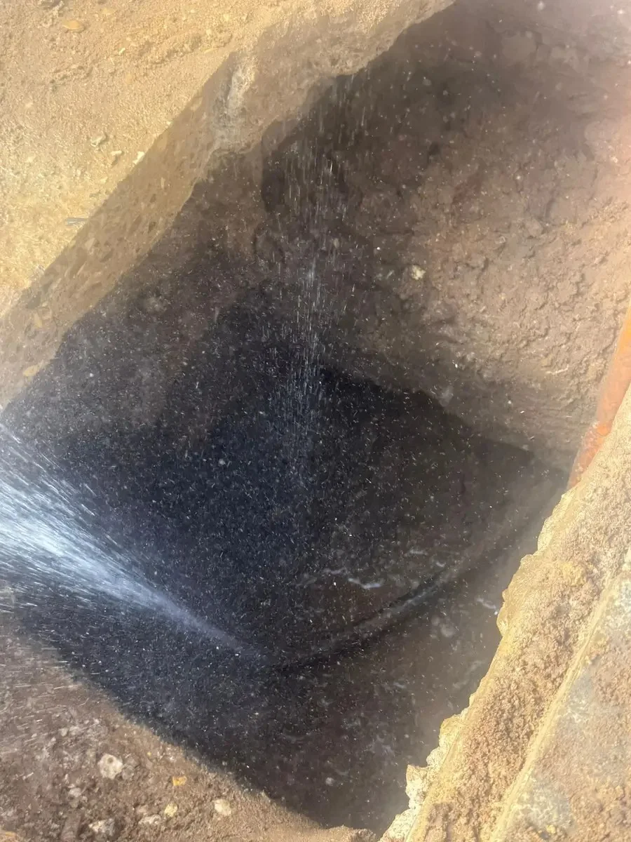 Water escaping from exposed underground pipework.