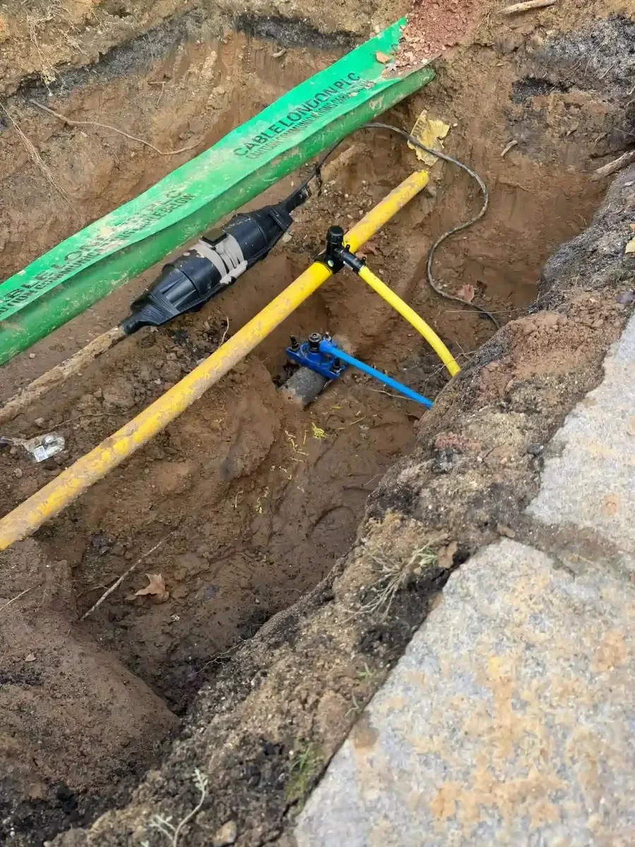Different utility ducts and pipes visible within a shared excavation.