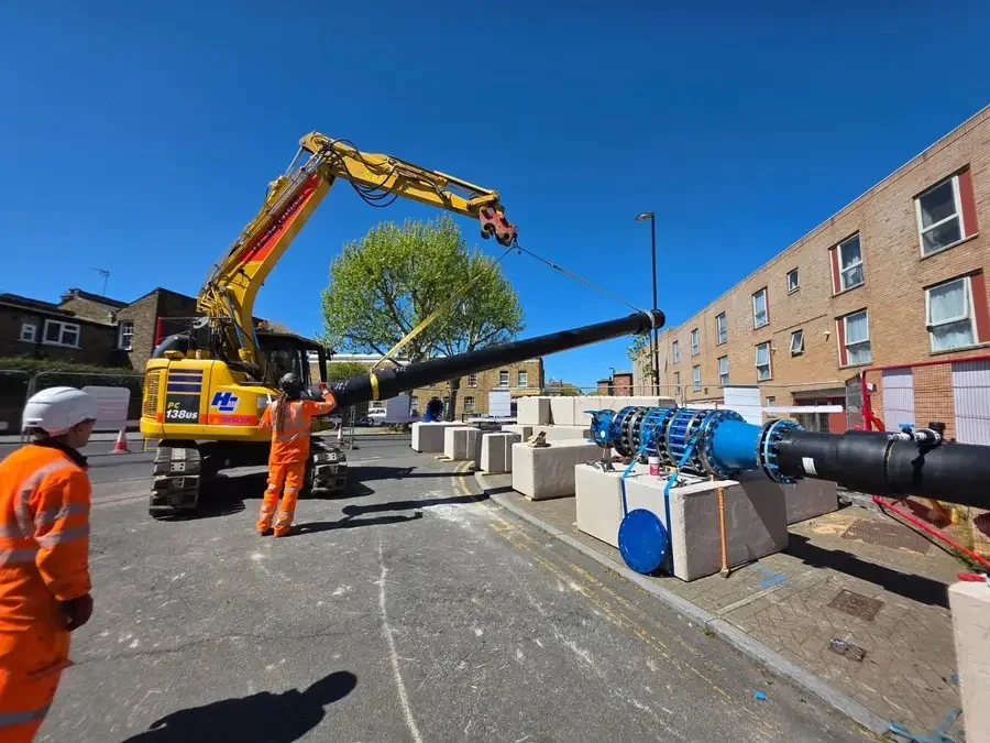 A water main being lifted into position during street works.
