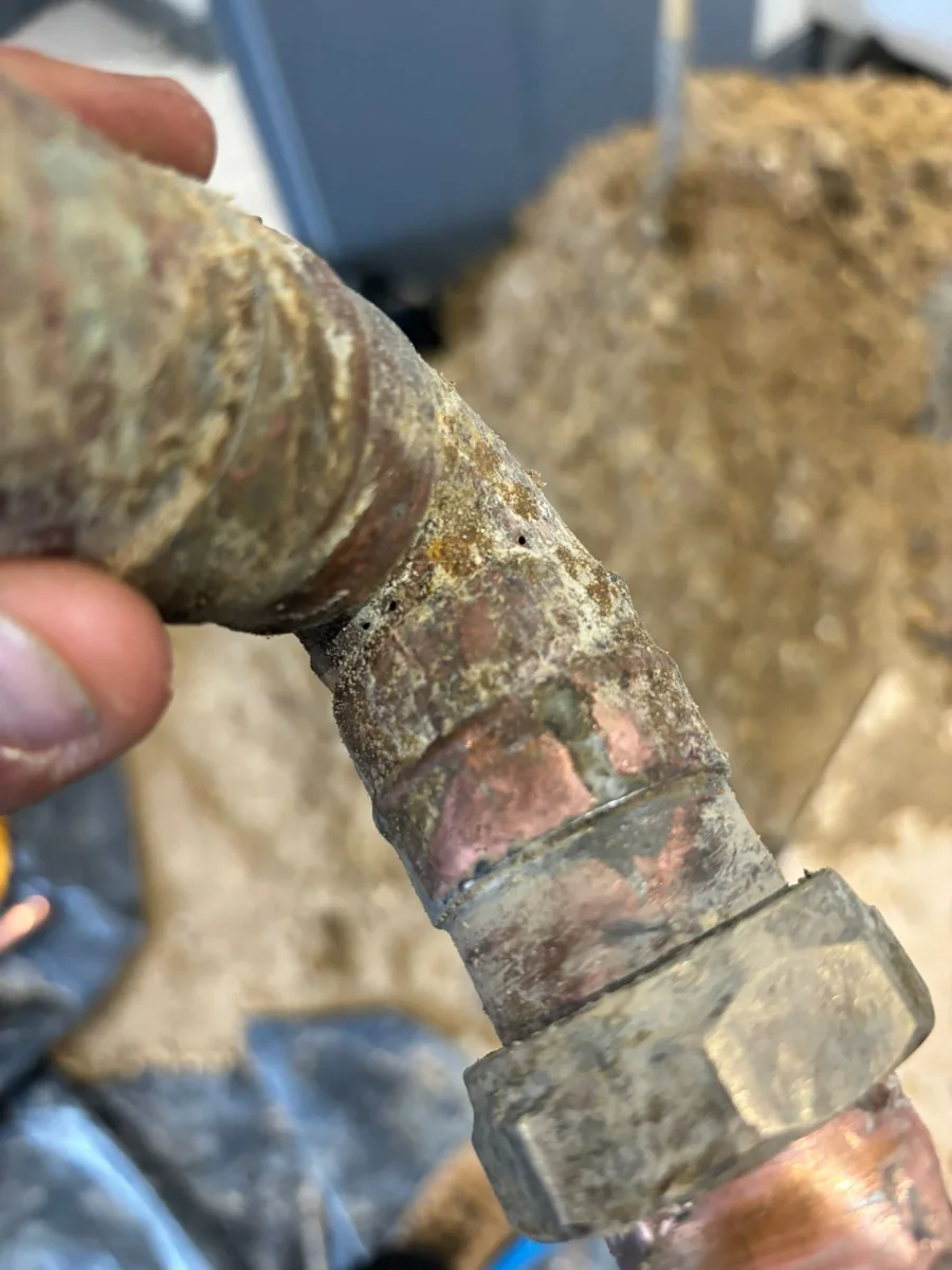 A removed pipe joint photographed during investigation work.