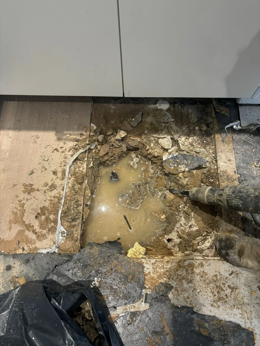Exposed floor construction and standing water at an investigation area.