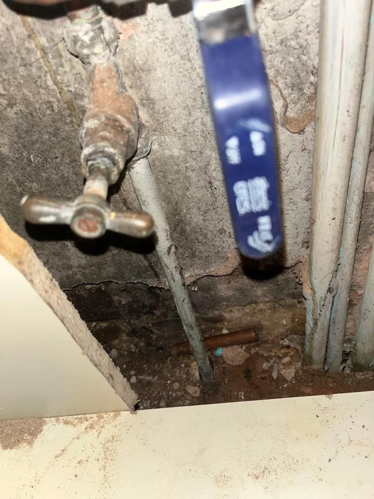 An existing stop valve and pipework within a service space.