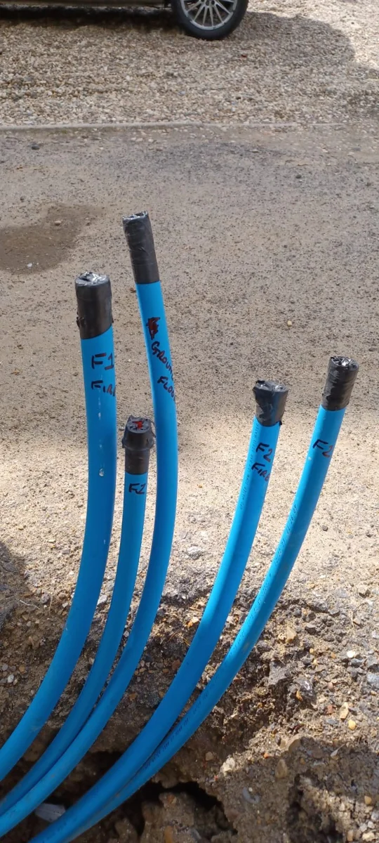 Capped blue supply pipes emerging from the ground.