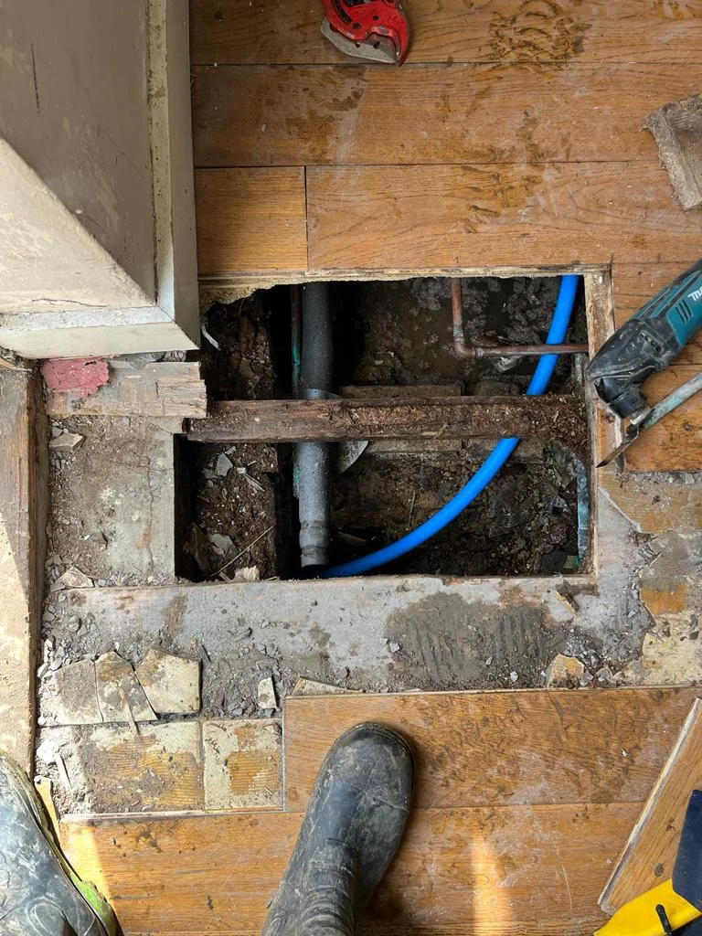Blue pipework routed through an opened floor section.