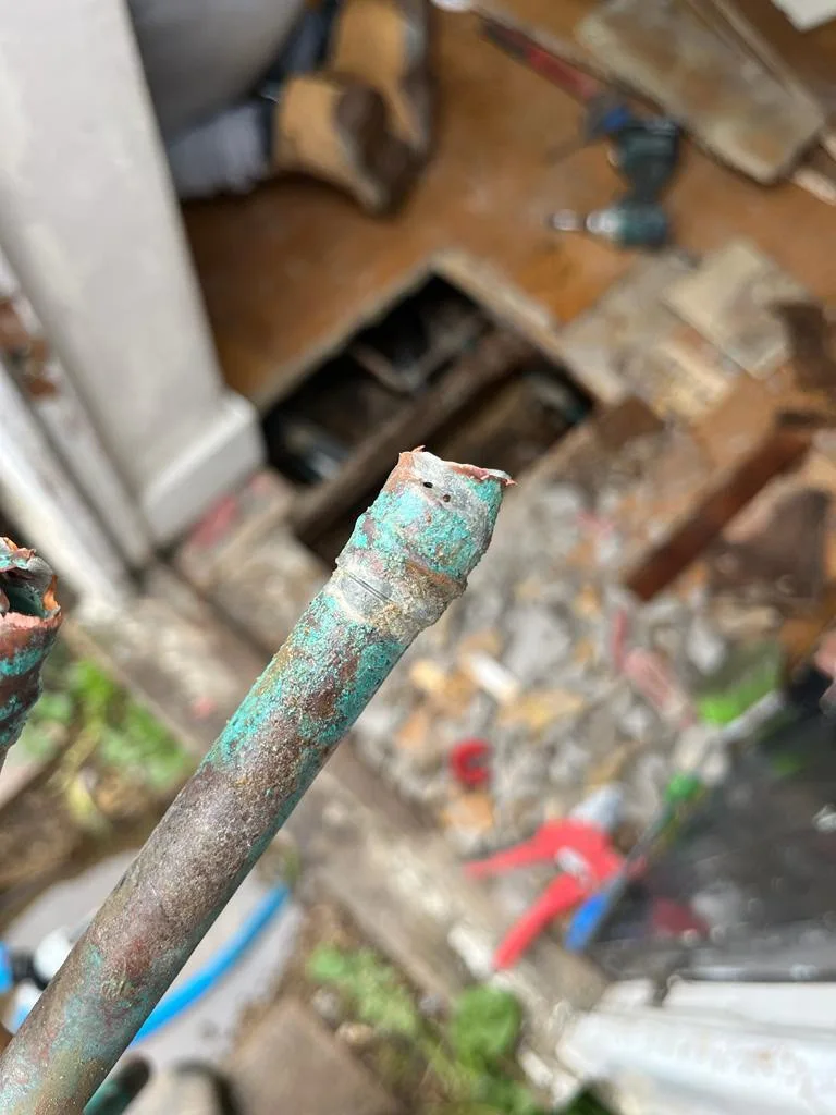 A close-up of removed copper pipework showing its condition.