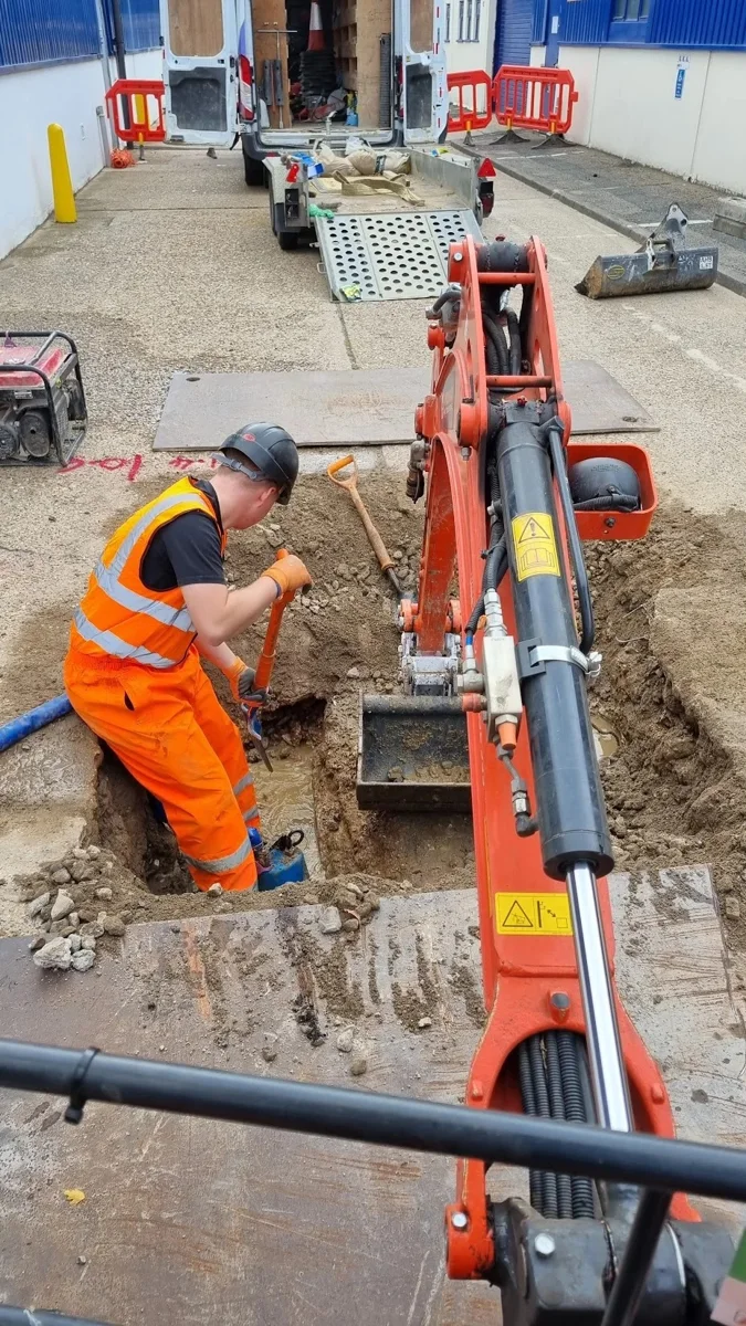 Engineers and excavation equipment at a barriered work area.
