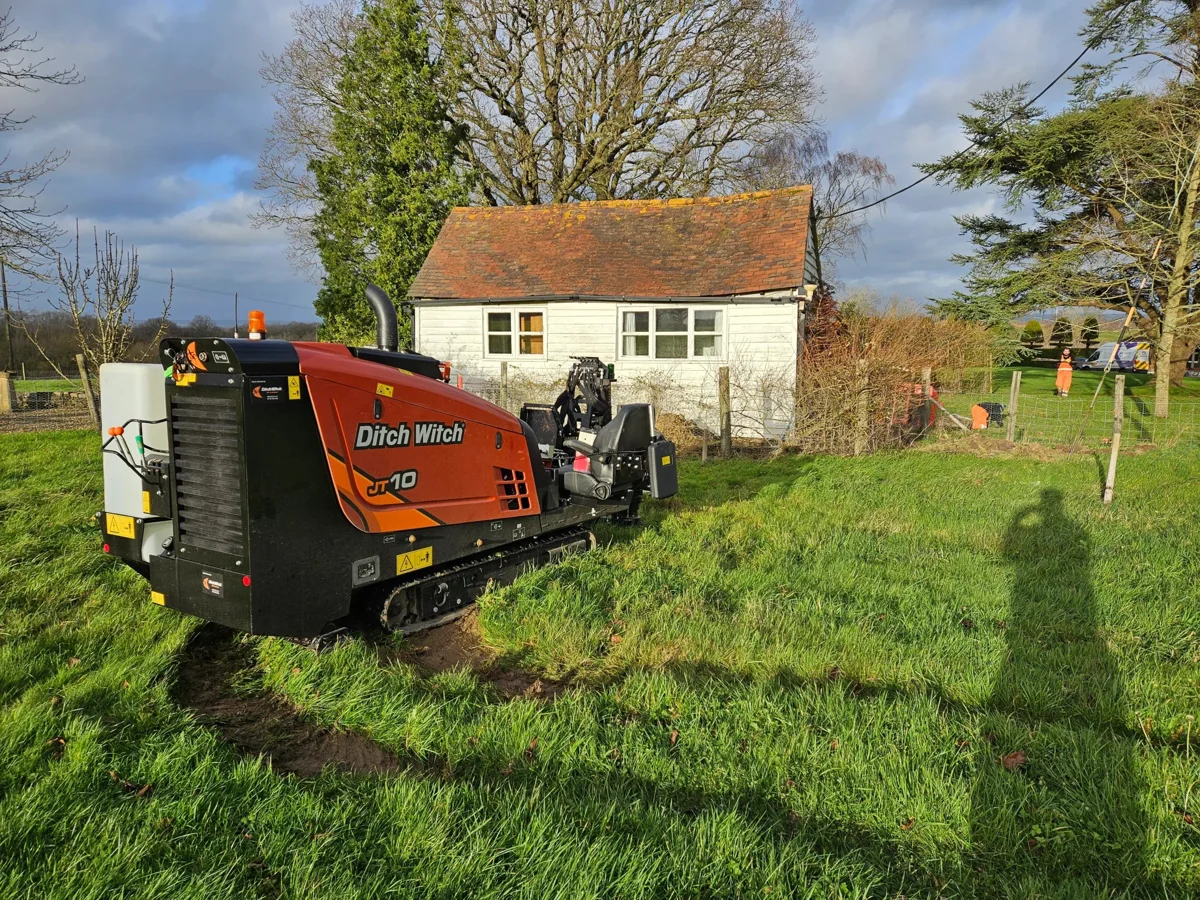 A compact directional drilling rig positioned beside a property.