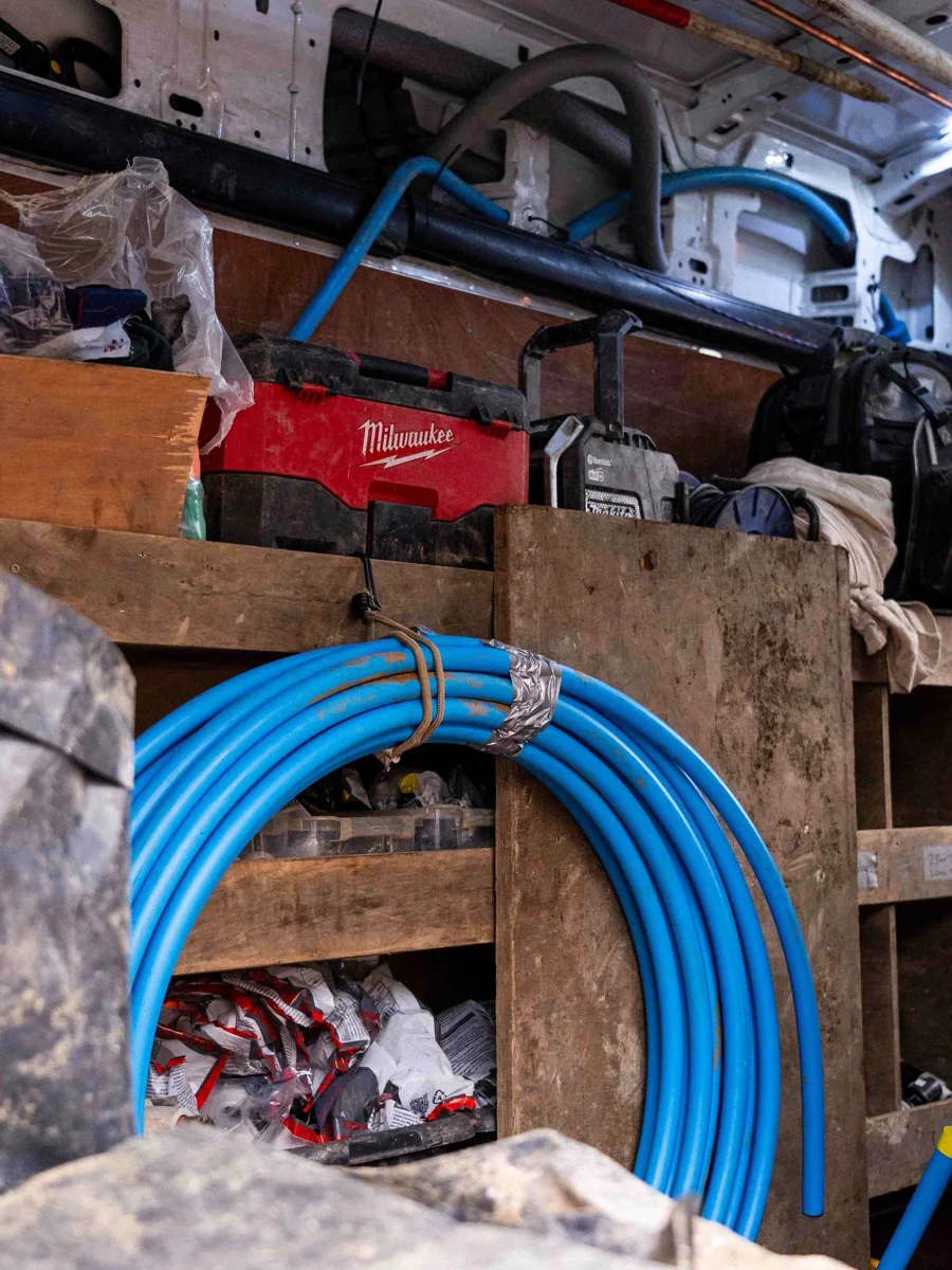 A coil of blue pipe alongside site tools and equipment.